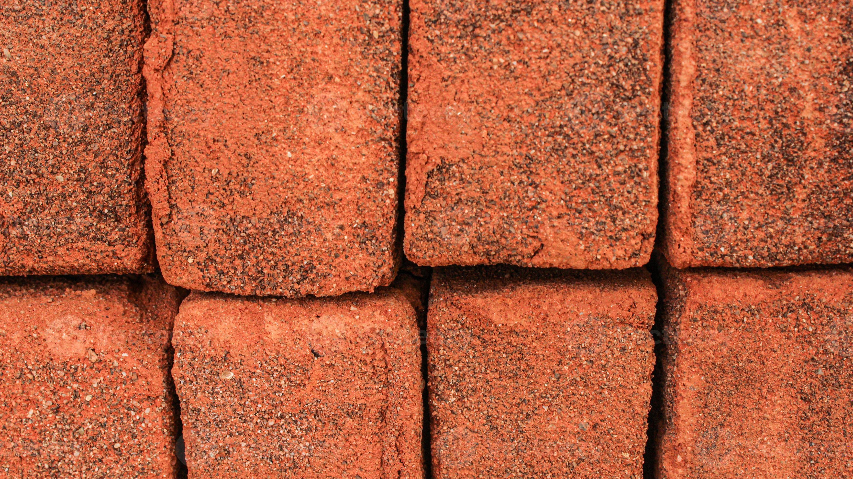 Arrangement of solid clay bricks used for construction, dark red brick, closeup view of red