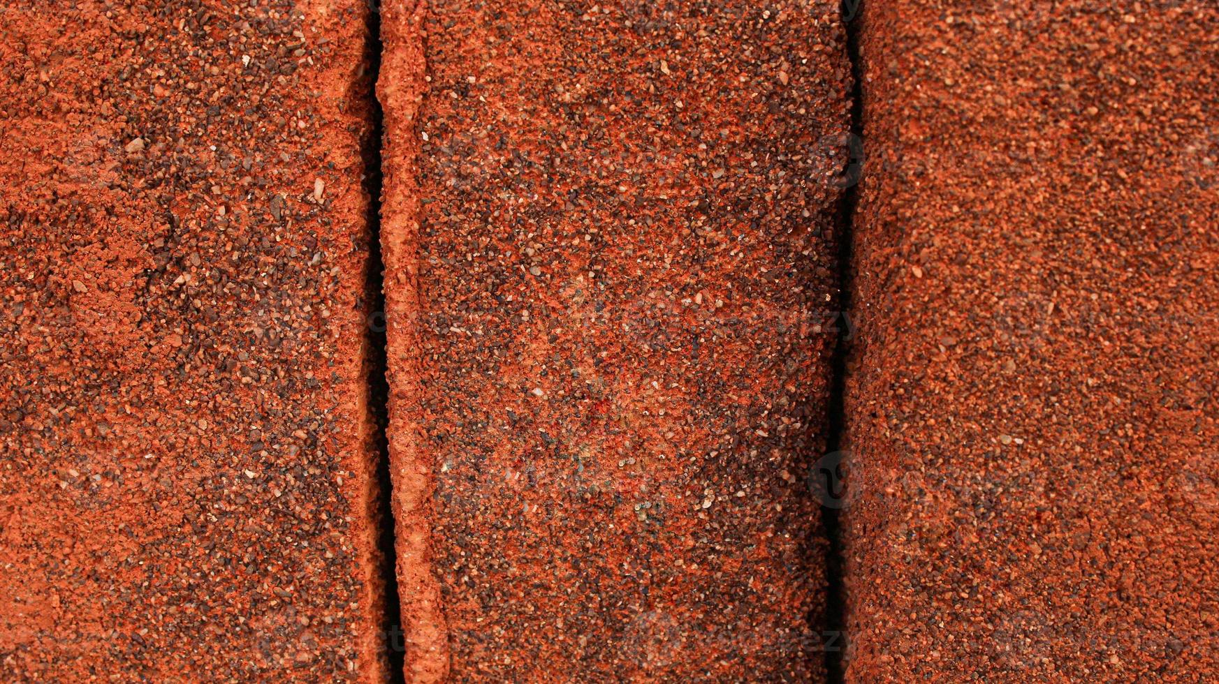 Rows of sandy red bricks. Red background of red bricks. arrangement of solid clay bricks used for construction, dark red brick, closeup view of red bricks as building materials, pile of brickwork photo