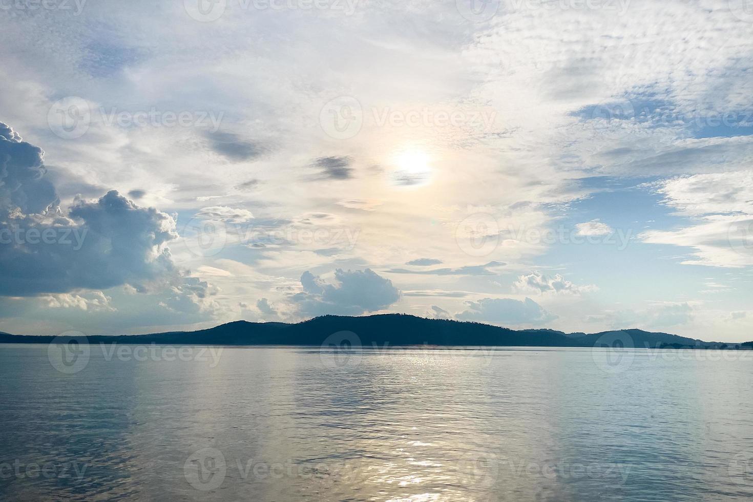 the shoreline of the river in the rays of the sun photo