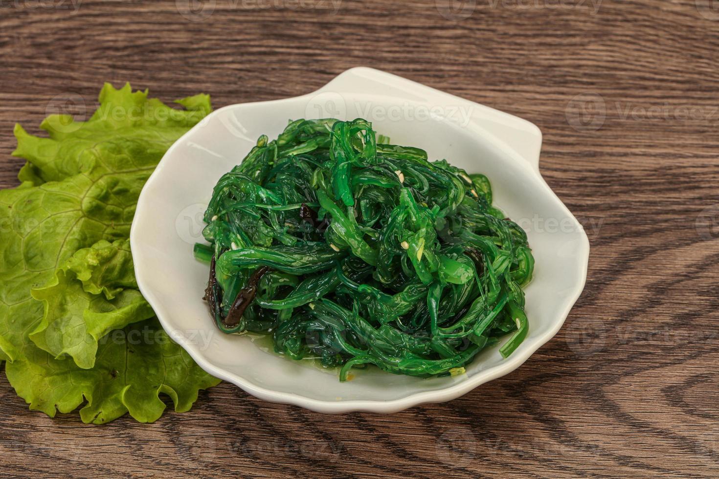 Green Chuka Seaweed Salad Isolated on White Background Top View. Wakame Sea Kelp Salat photo