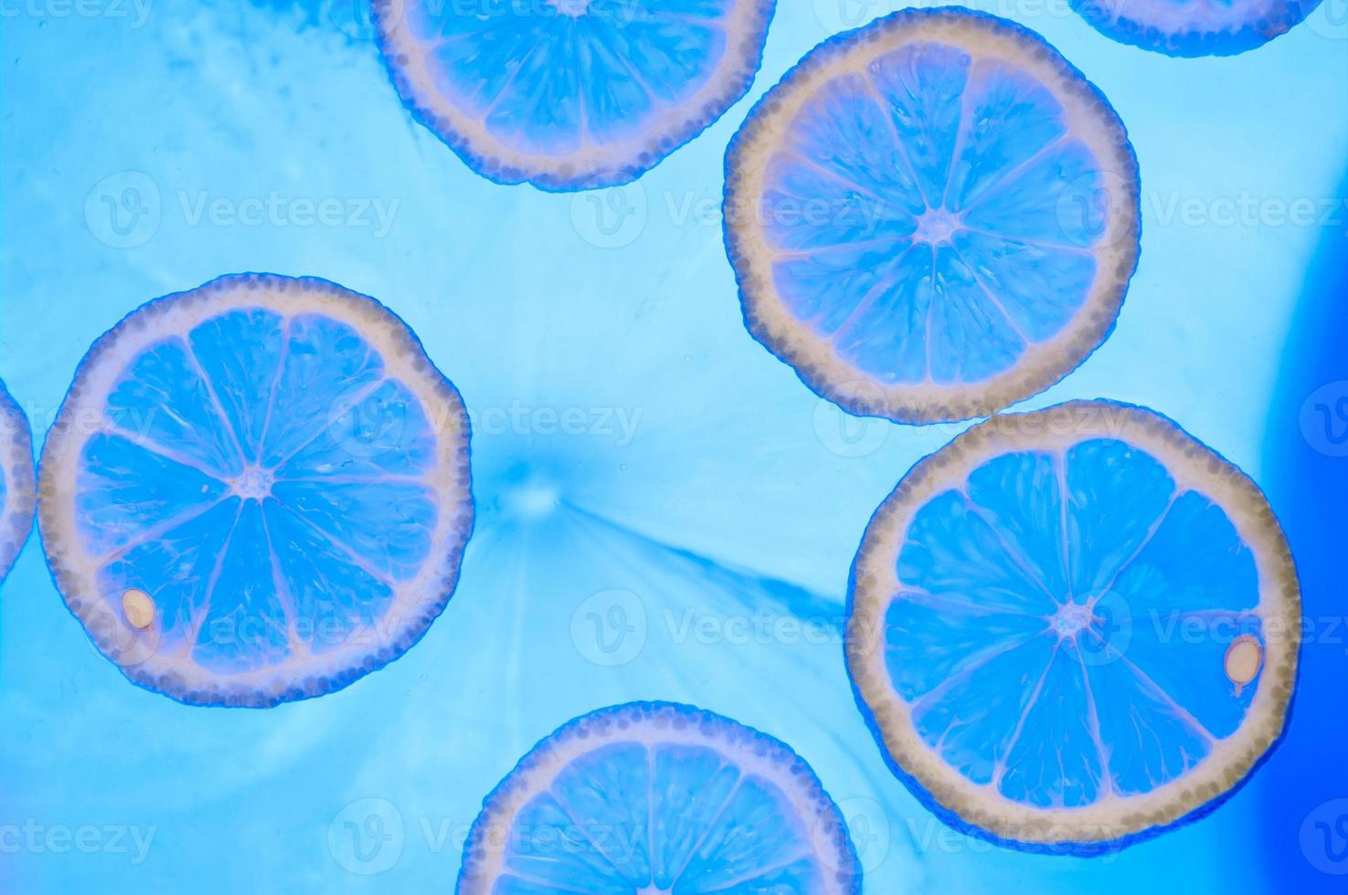 Abstract blue image of lemon slices. Blue lemon background. photo
