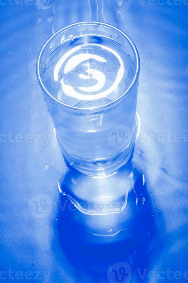 Glass of cold water in blue monochrome. photo