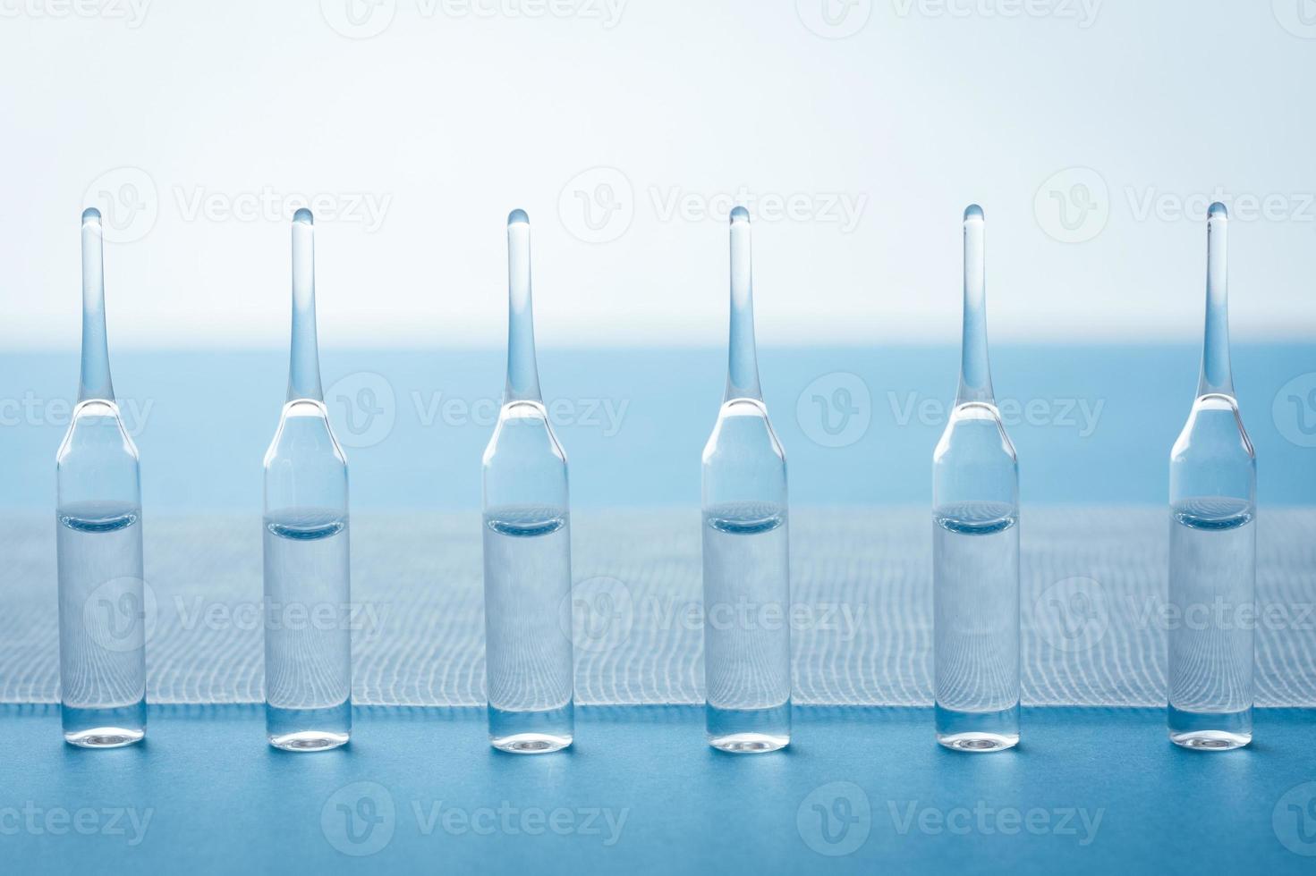 Ampules standing in a row on blue background. photo