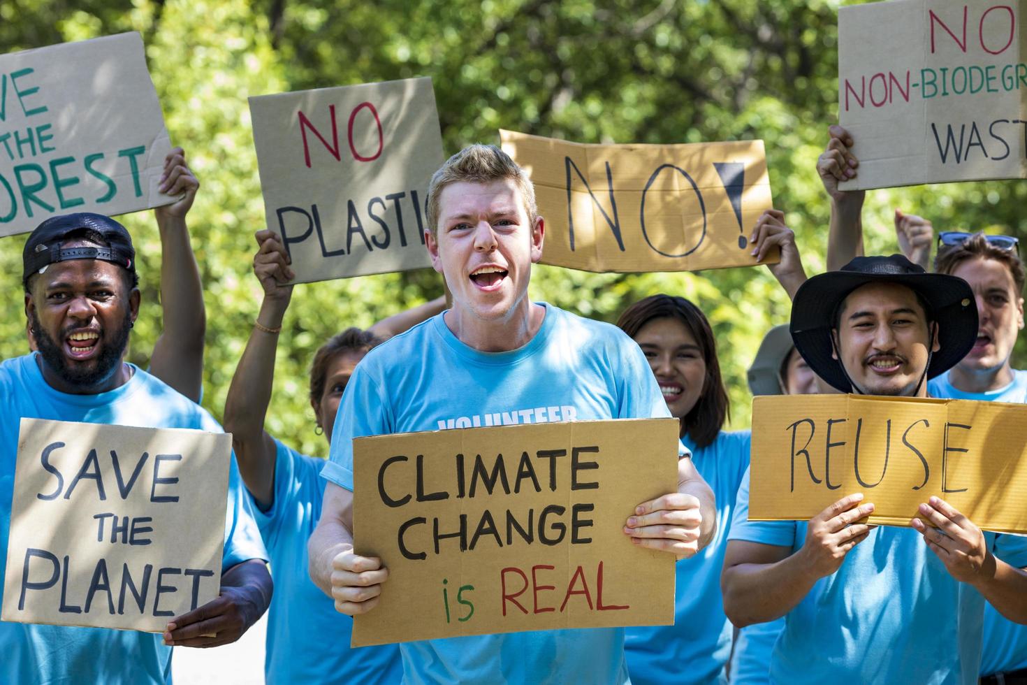 Diversity group of volunteer activist demonstrating in protest for global warming and climate change project with written placard for environmental awareness and reducing plastic consumption concept photo