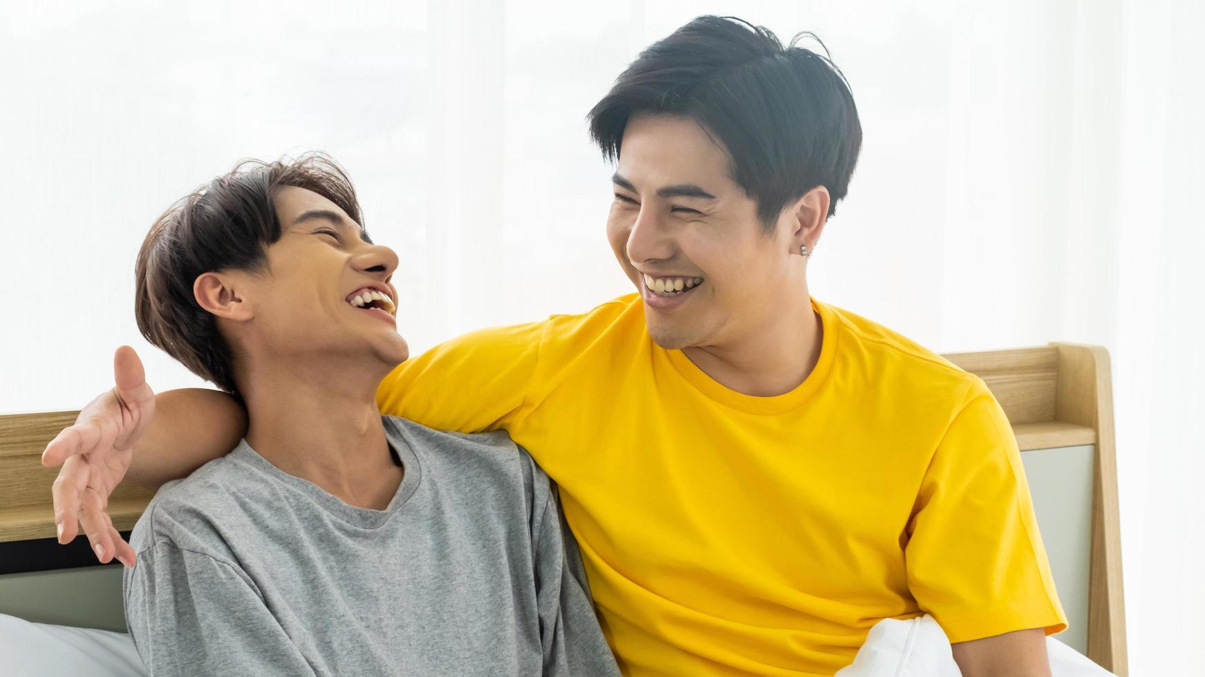 Asian gay homosexual couple hug and embracing on the bed.  Gender equality and right concept, playful and romantic moment. photo