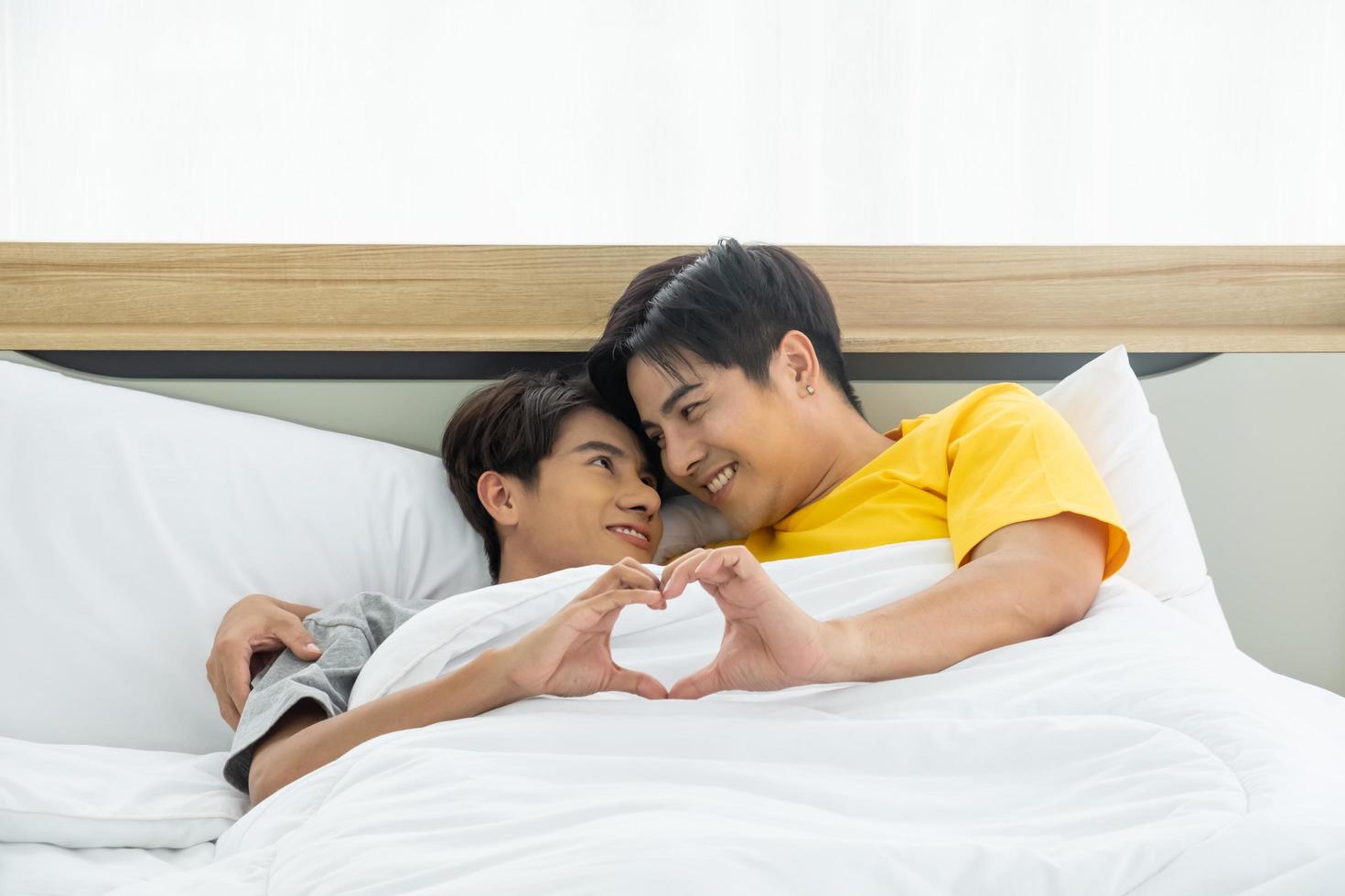 Asian gay homosexual couple hug and embracing on the bed.  Gender equality and right concept, playful and romantic moment. photo