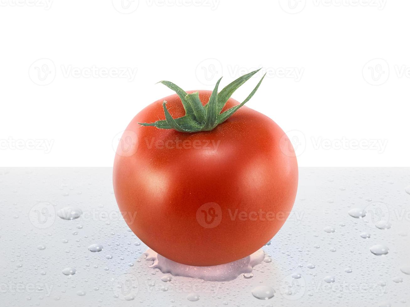 tomate fresco sobre la mesa con gotas de agua foto