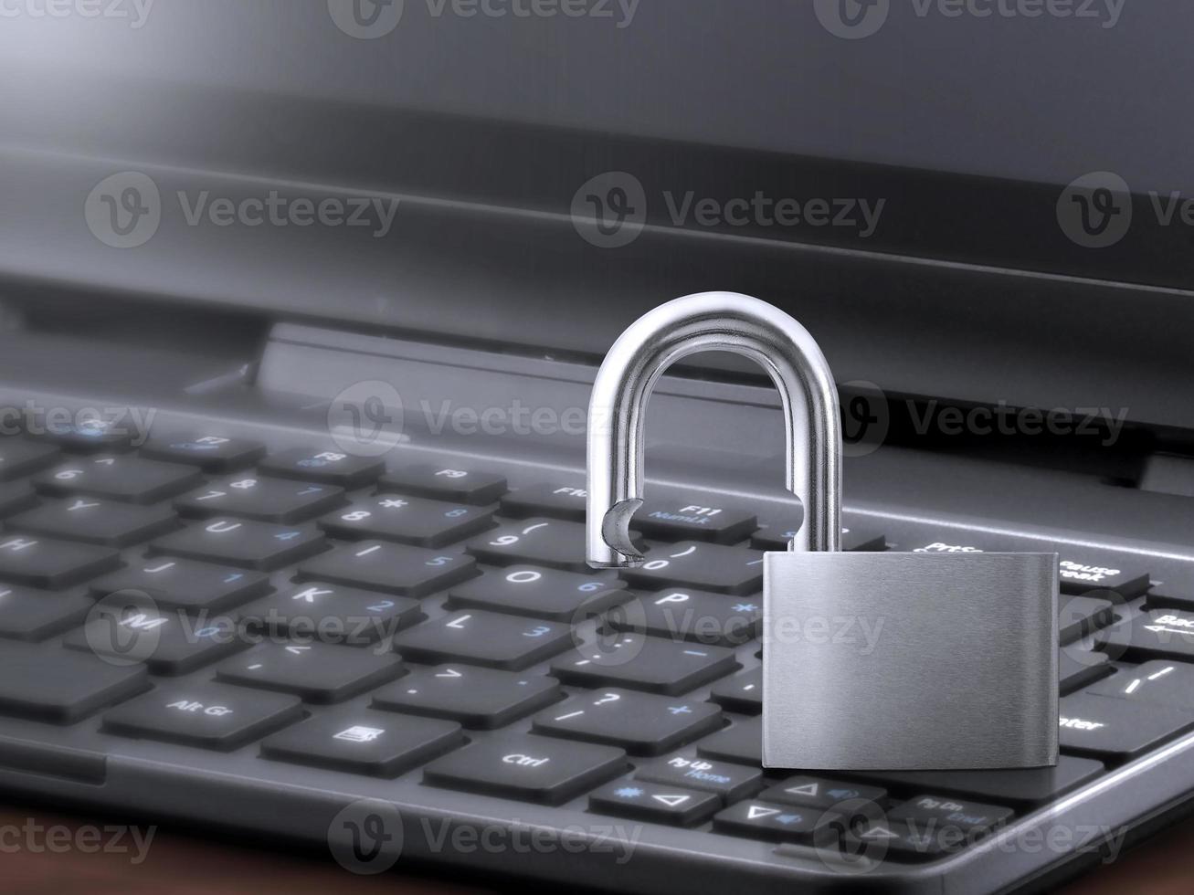 Computer security concept. Unlocked padlock on laptop keyboard. Symbol of safe. Toned soft focus picture photo