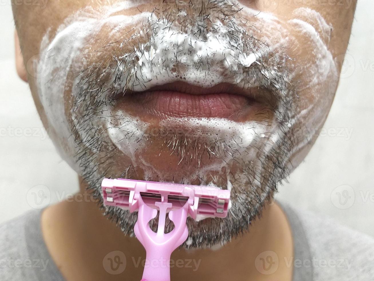 Close up of male shaving with razor photo