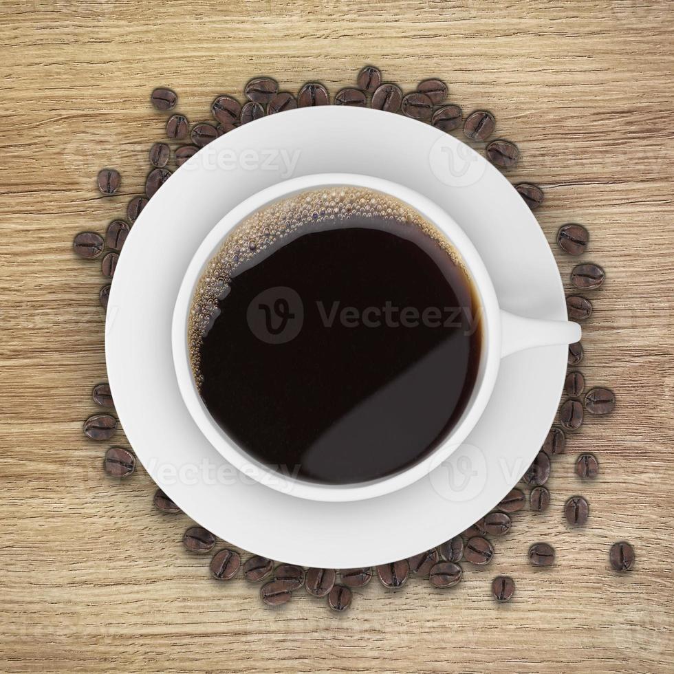Top view of a Coffee cup and beans, on a wooden table photo
