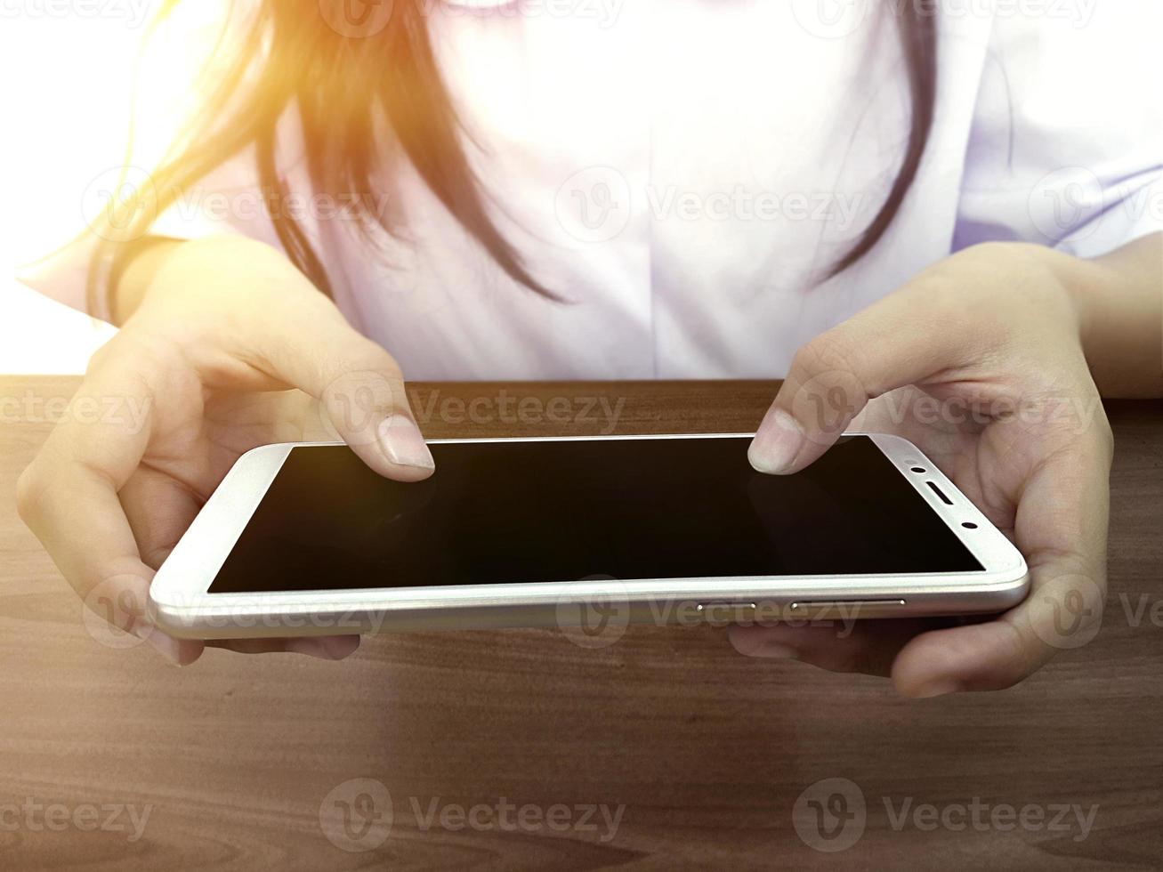 Close-up of kid's hands close up holding digital Smart phone for playing and education photo