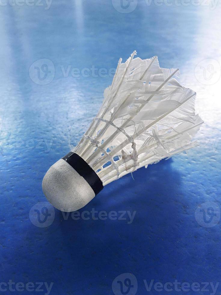 Shuttlecock white badminton ball on the blue court photo