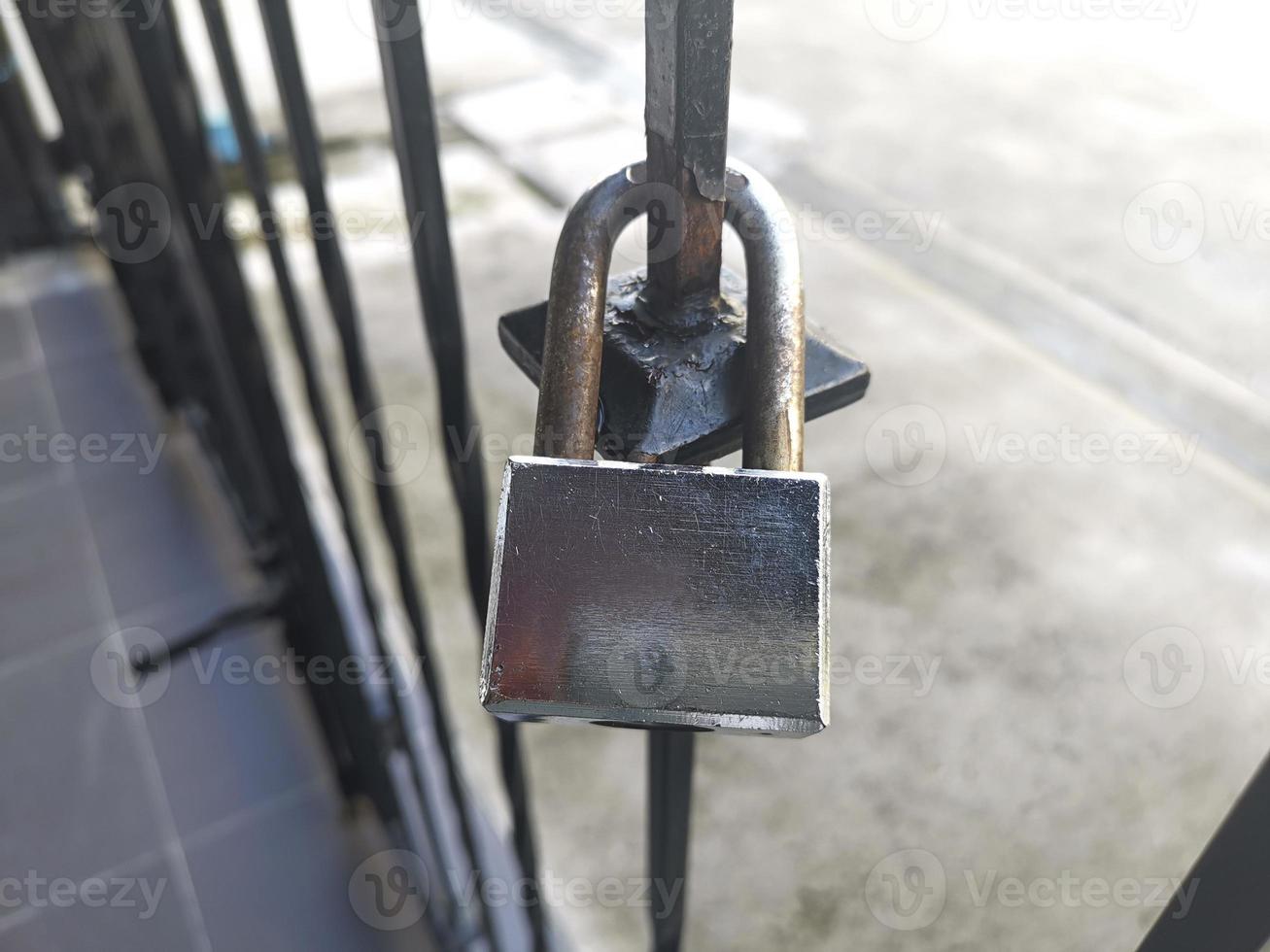 Old Locked Padlock Hanging On The Old Fashioned Metal Gate photo