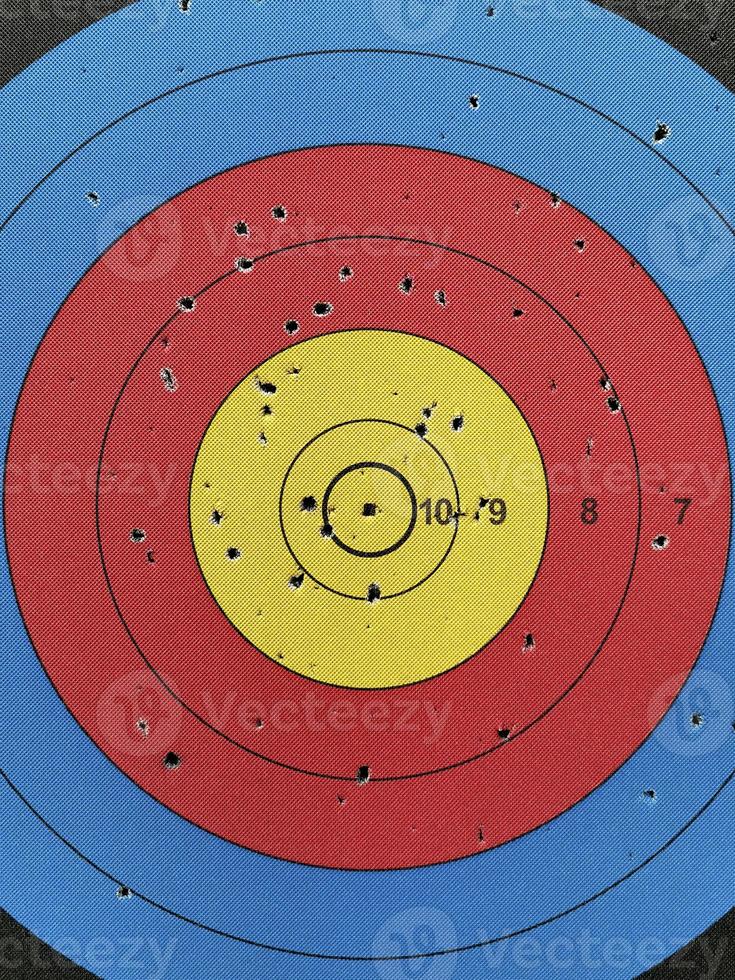 Numbered used dart board with number and full of dart holes photo