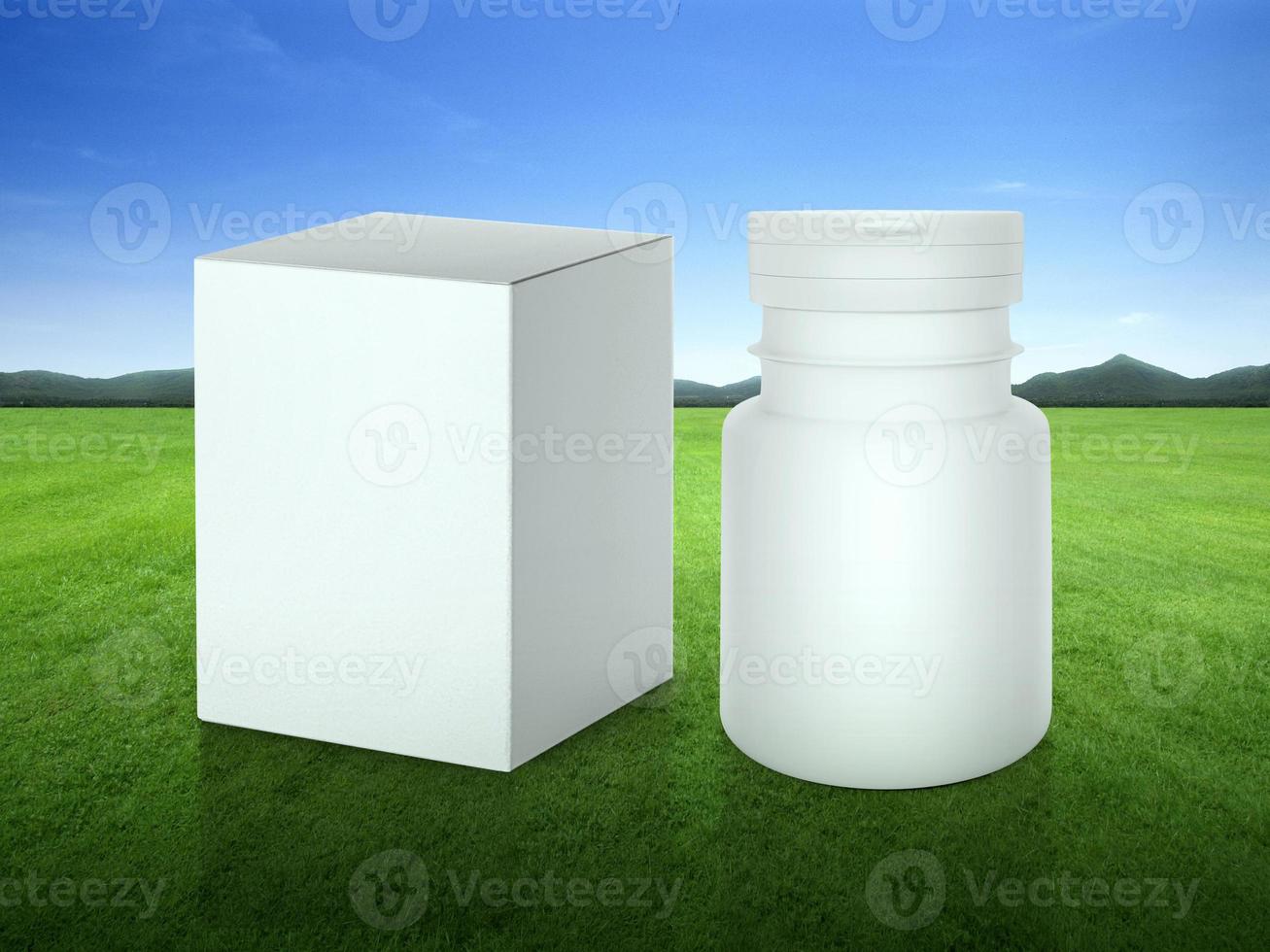 Close up blank medicine bottle and package on green grass field on green fairway with beautiful blue sky photo