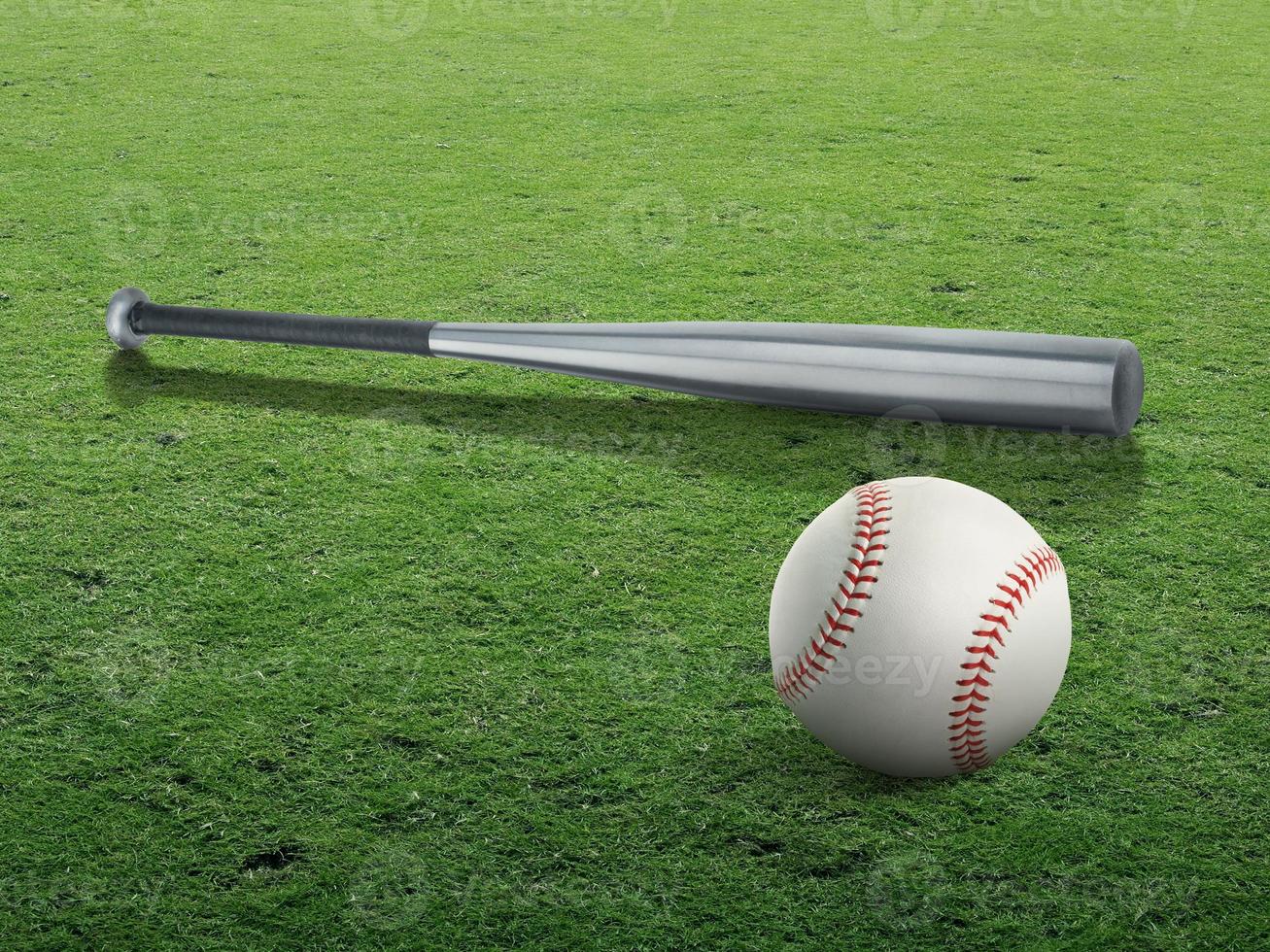 Baseball bat and ball on the green grass turf photo