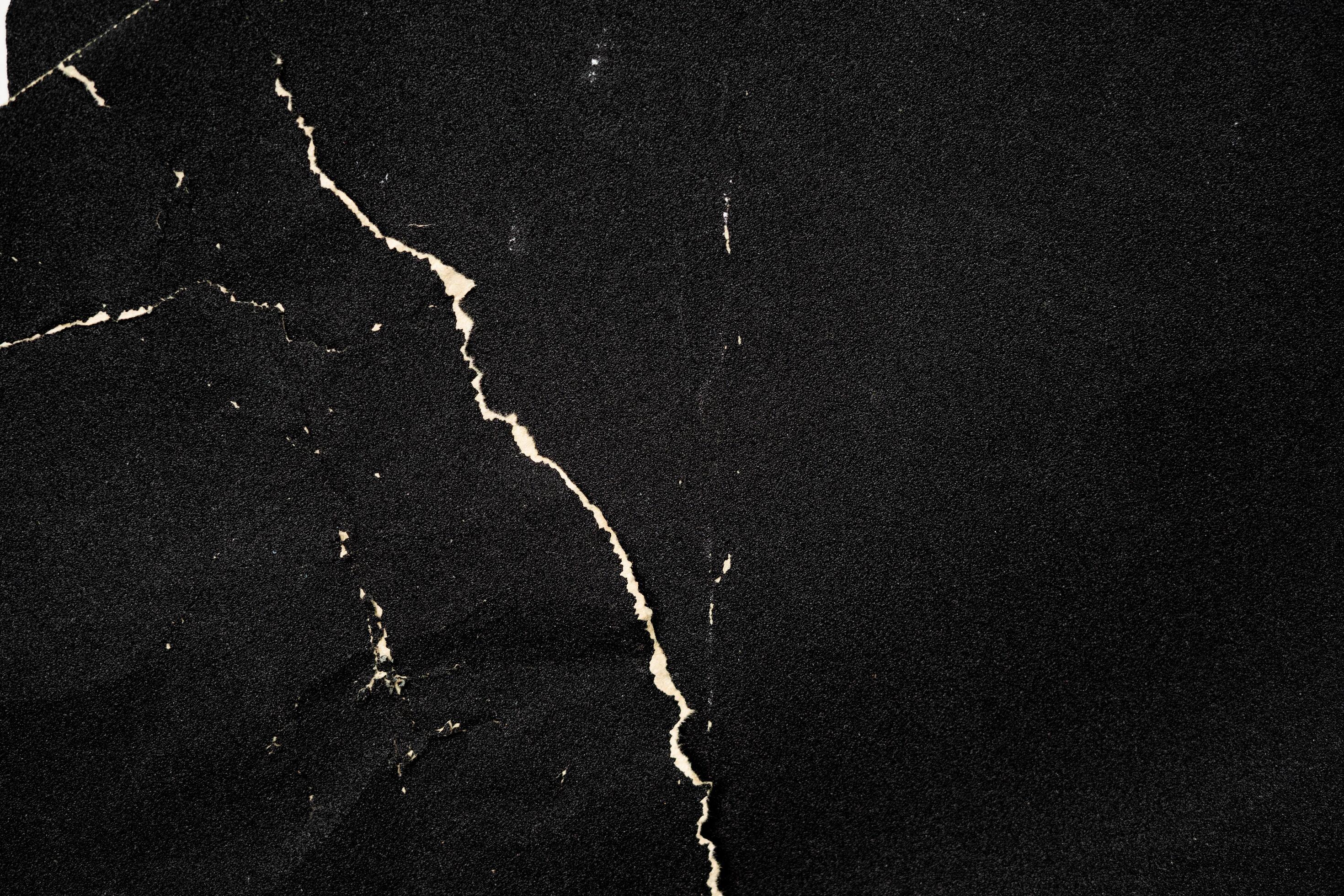 Crumpled black paper with a detailed texture. Close up the paper with white  cracks. Rough paper texture for background. 8617415 Stock Photo at Vecteezy