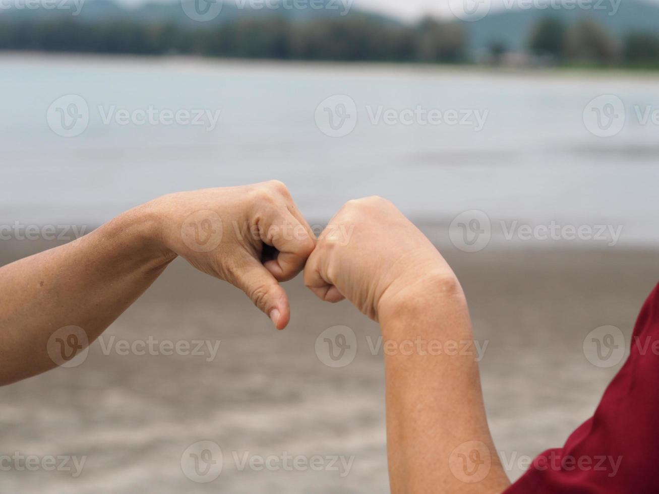 Two woman Alternative handshakes fist clenched hand greeting in the situation of an epidemic covid 19, coronavirus new normal social distancing photo