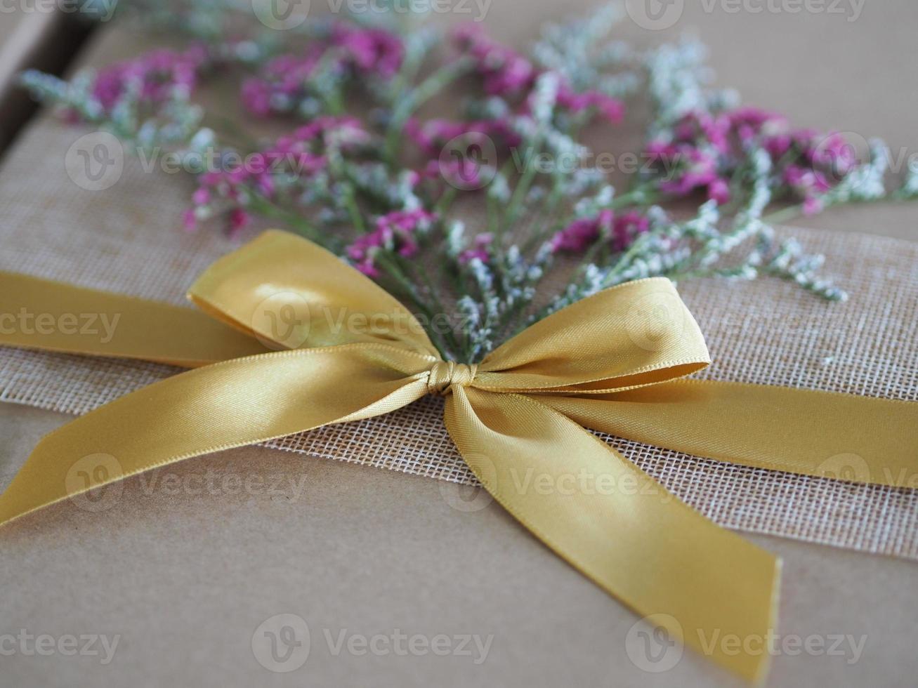 brown paper gift box tied with a golden ribbon and decorated with dried flowers, Festival Gifts for Christmas and Happy New Year photo