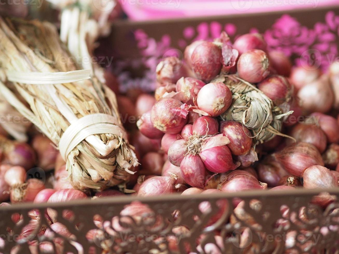 Small onion in a bunch, placed in a brown plastic basket photo