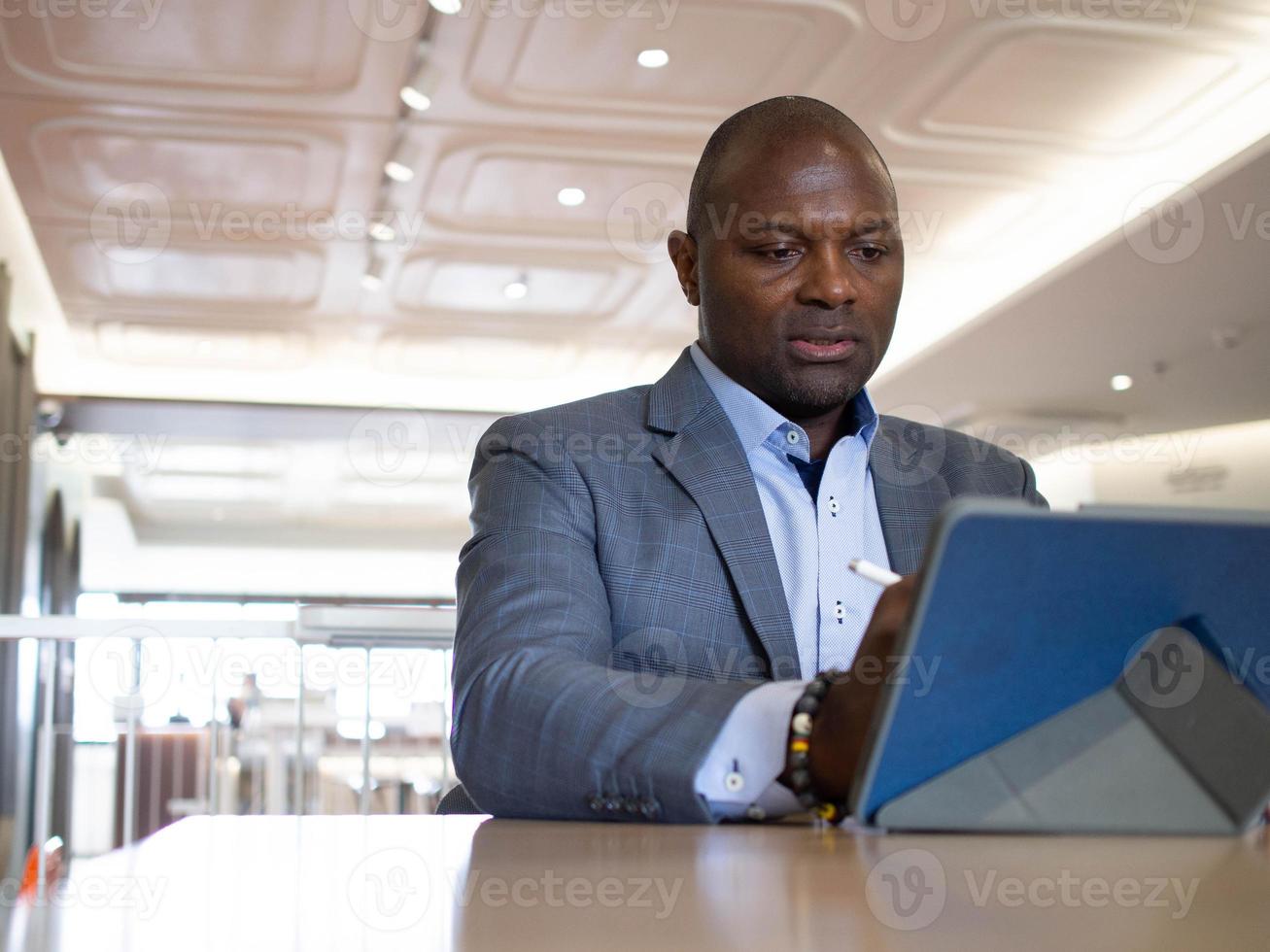 empresario jefe gerente Sudáfrica brasileño retrato persona inteligente  guapo está sentado trabajo carrera tableta cuaderno teléfono móvil  computadora tecnología digital en línea Internet inalámbrico red moderno  8619532 Foto de stock en Vecteezy