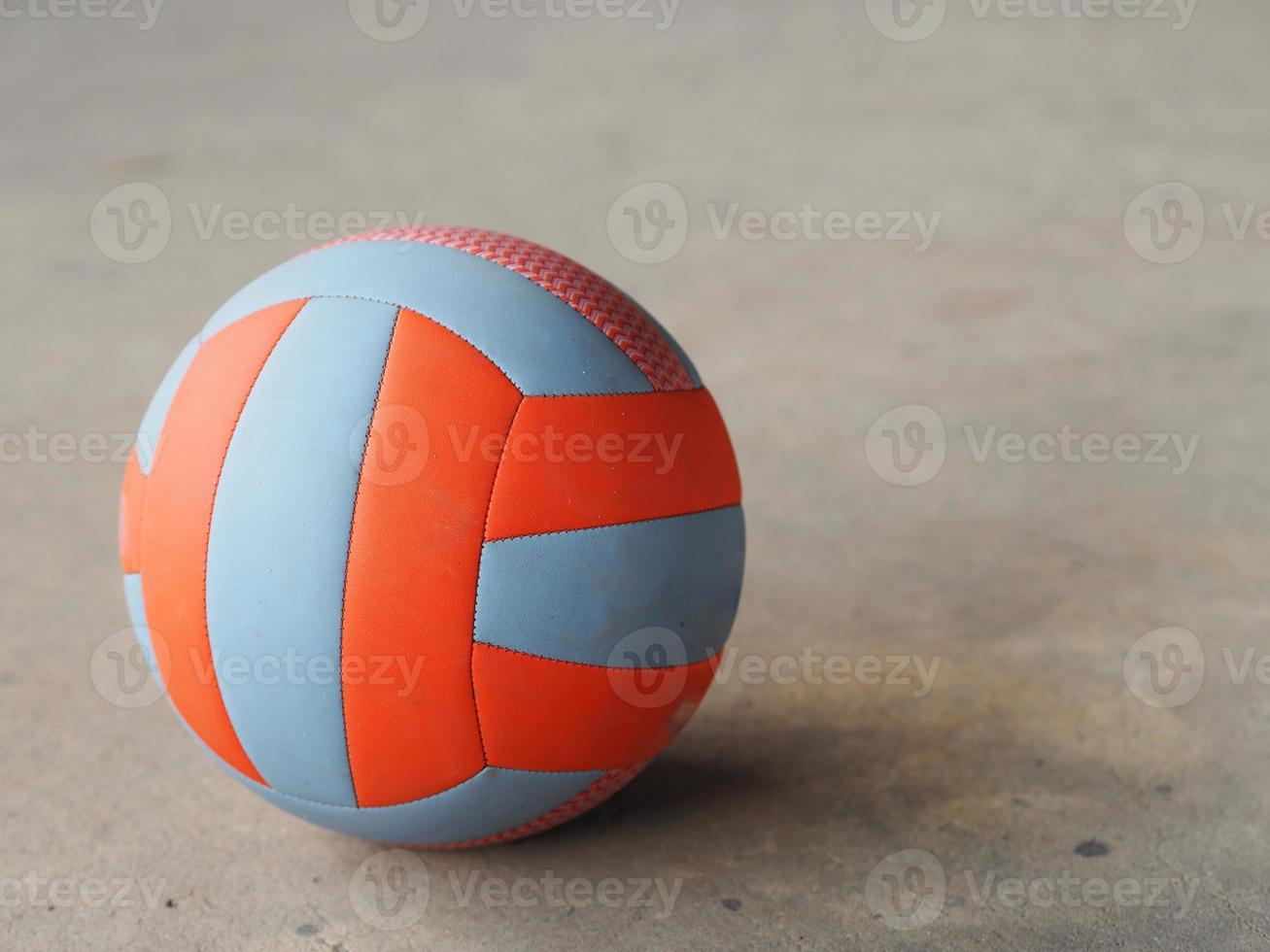 volley ball placed on the concrete ground, blue and orange color, sport photo