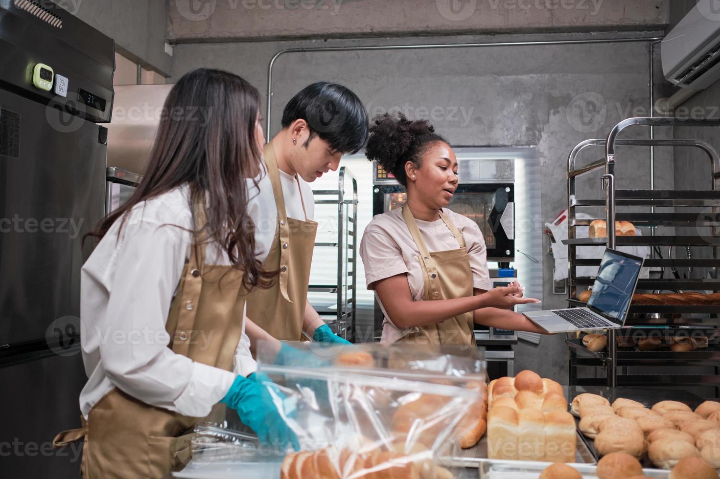 Three young friends and startup partners of bread dough and pastry foods busy with homemade baking jobs while cooking orders online, packing, and delivering on bakery shop, small business entrepreneur photo