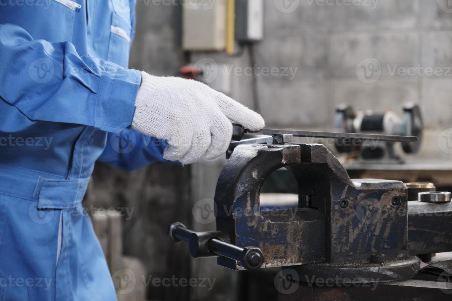 Close-up of professional industry male worker's hands with protective gloves works with metalwork precision tools, mechanical lathe machines, and spare parts workshop in a steel manufacturing factory. photo
