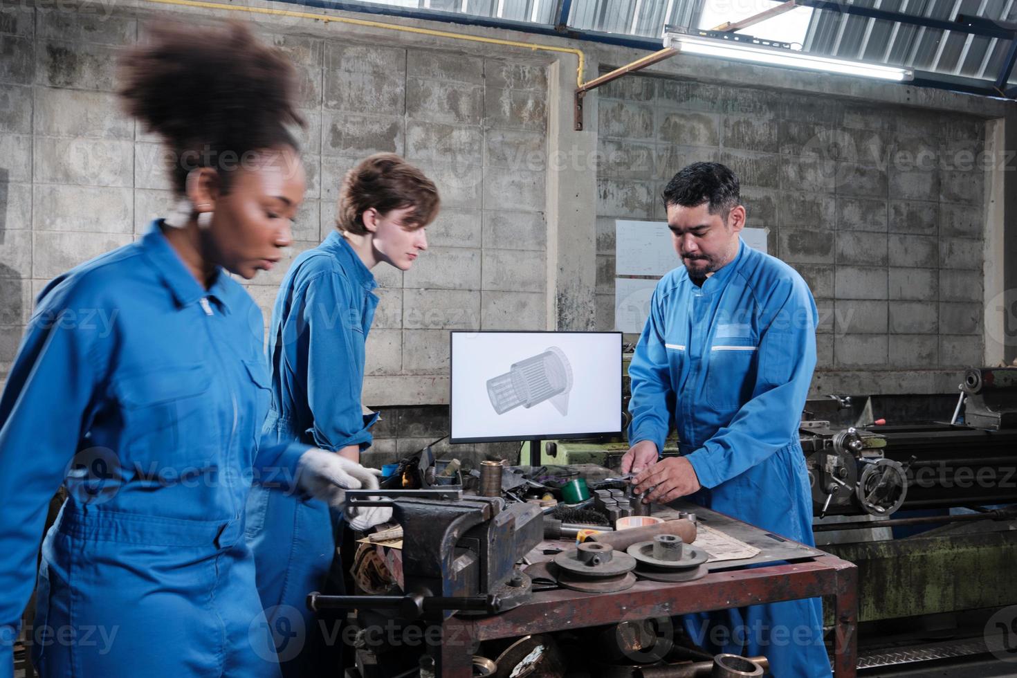 Three multiracial professional industry engineer workers teams in safety uniforms metalwork jobs discuss with mechanical drawing in a monitor, lathe machines, and workshop in manufacturing factory. photo