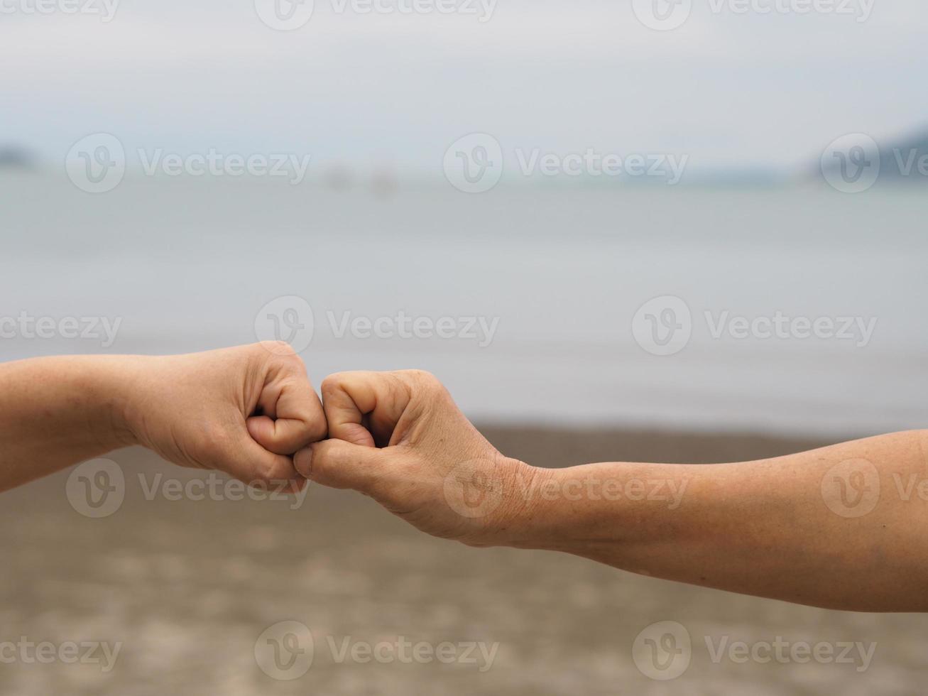 Two woman Alternative handshakes fist clenched hand greeting in the situation of an epidemic covid 19, coronavirus new normal social distancing photo