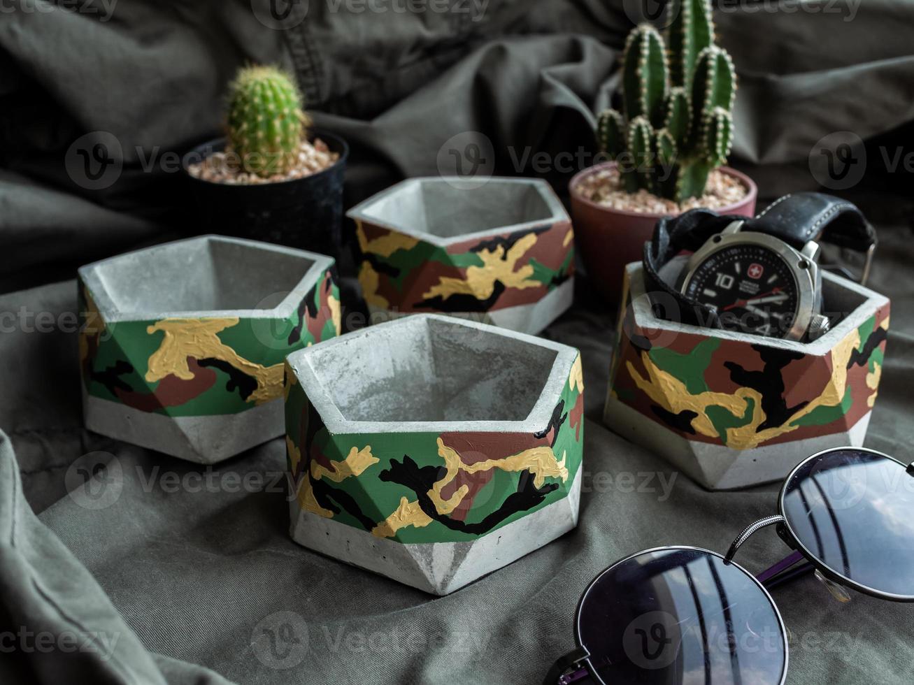 Pentagon concrete planters with camouflage pattern painting. Painted concrete pots for home decorations photo