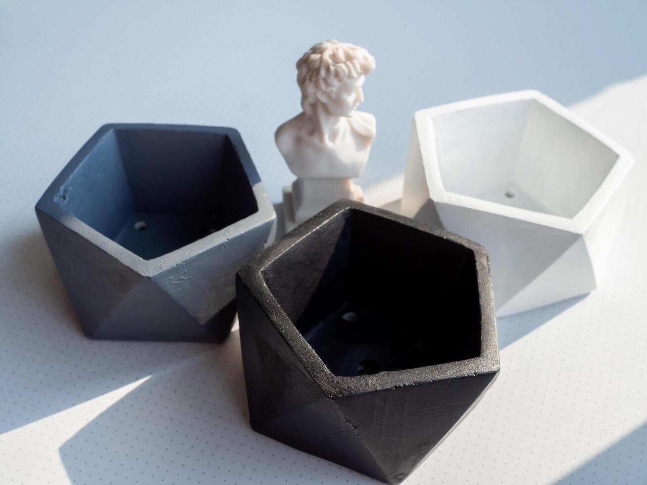 Modern pentagon concrete planters. Painted concrete pots for home decoration photo