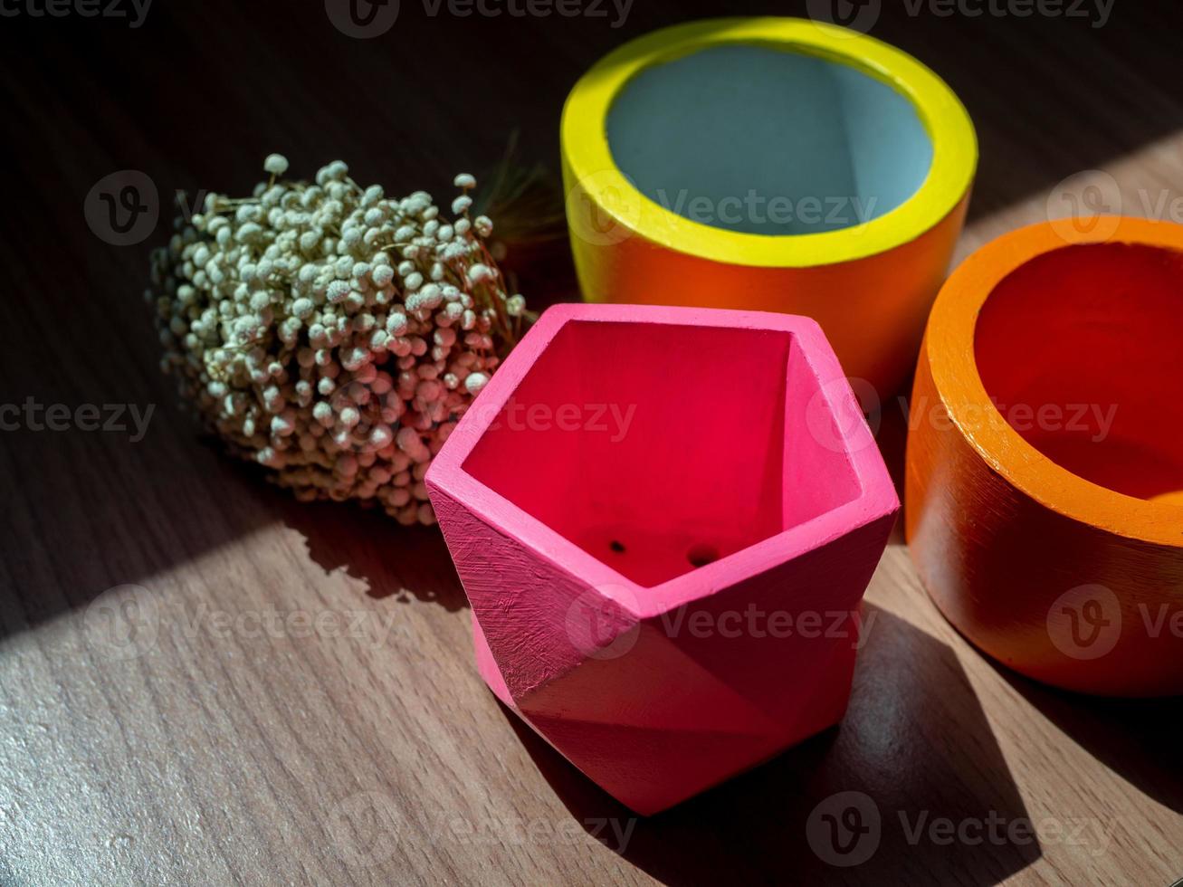 Beautiful various geometric concrete planters with dried flower. Colorful painted concrete pots for home decoration photo