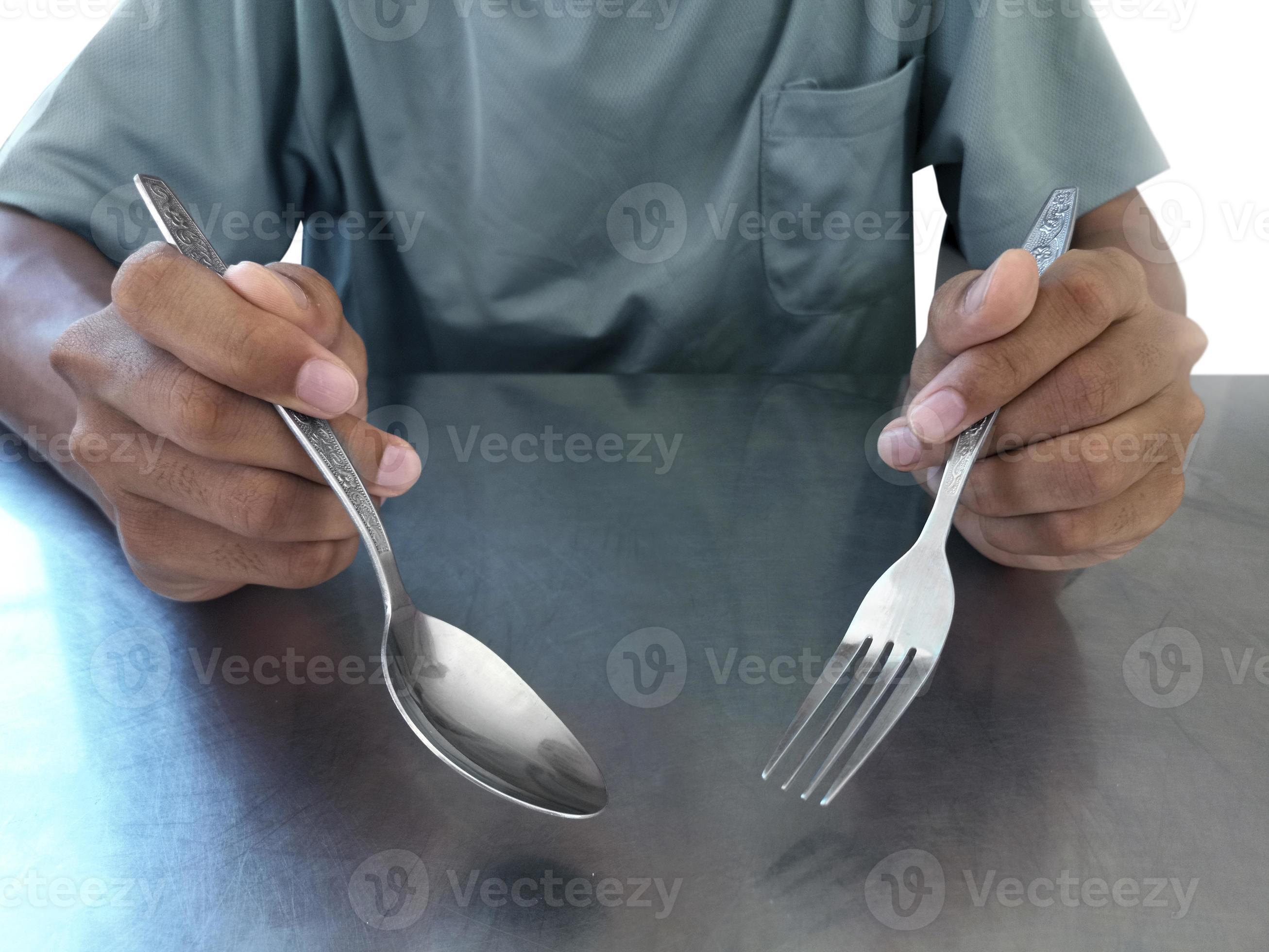 Man hand holding a silver fork and spoon 8621499 Stock Photo at Vecteezy