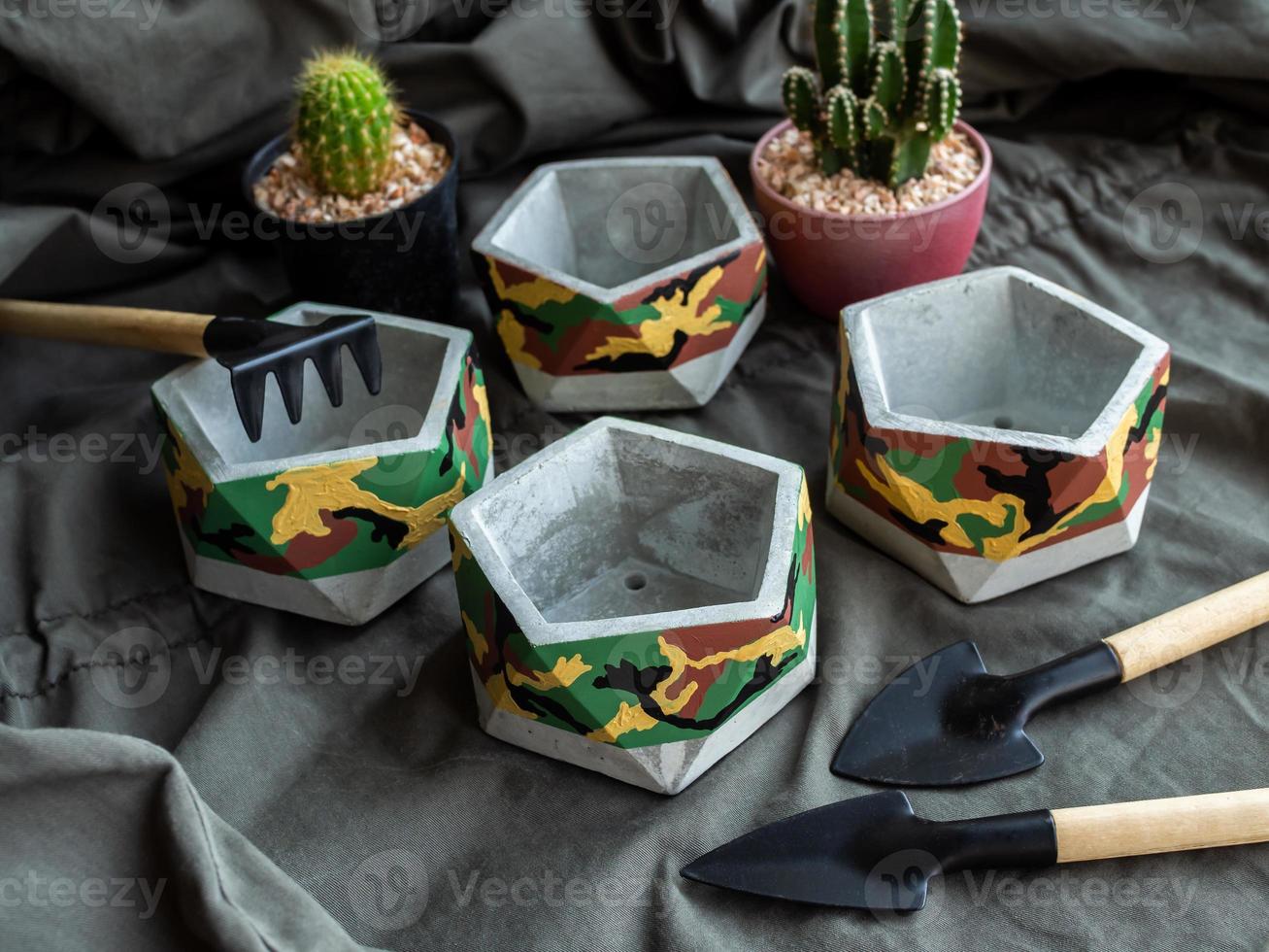 Pentagon concrete planters with camouflage pattern painting. Painted concrete pots for home decorations photo