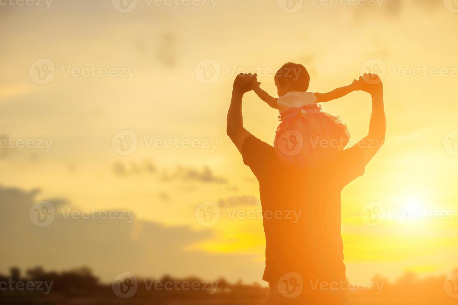 Father took the baby learn to walk at sunset. photo