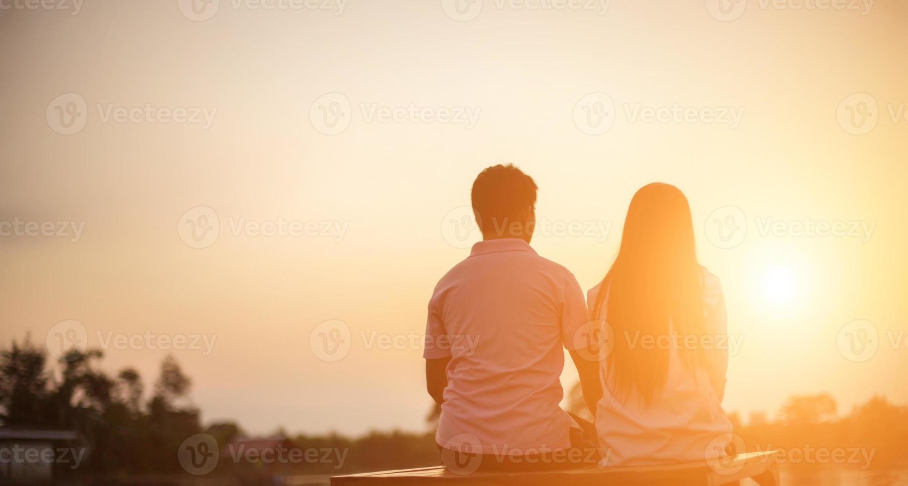 a silhouette of a man and woman holding hands with each other, walking together. photo