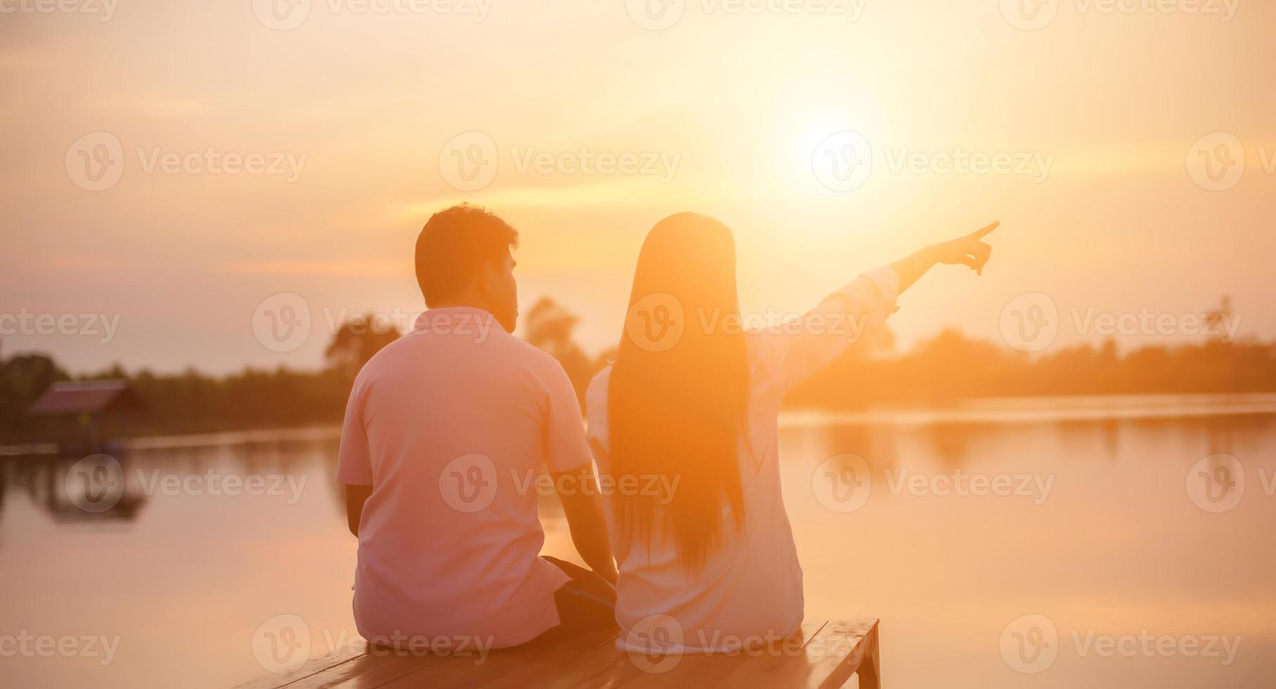 a silhouette of a man and woman holding hands with each other, walking together. photo