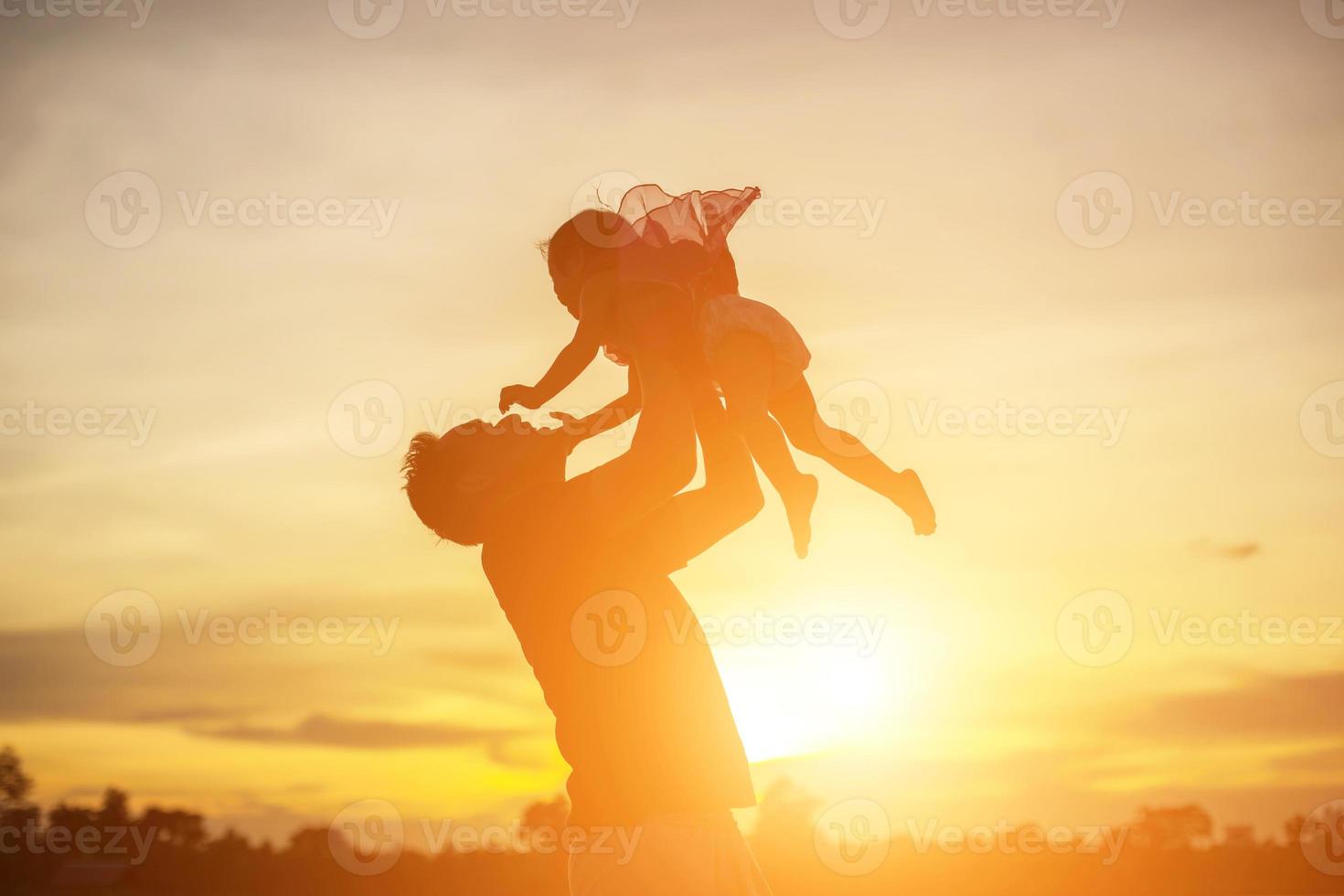 Father took the baby learn to walk at sunset. photo