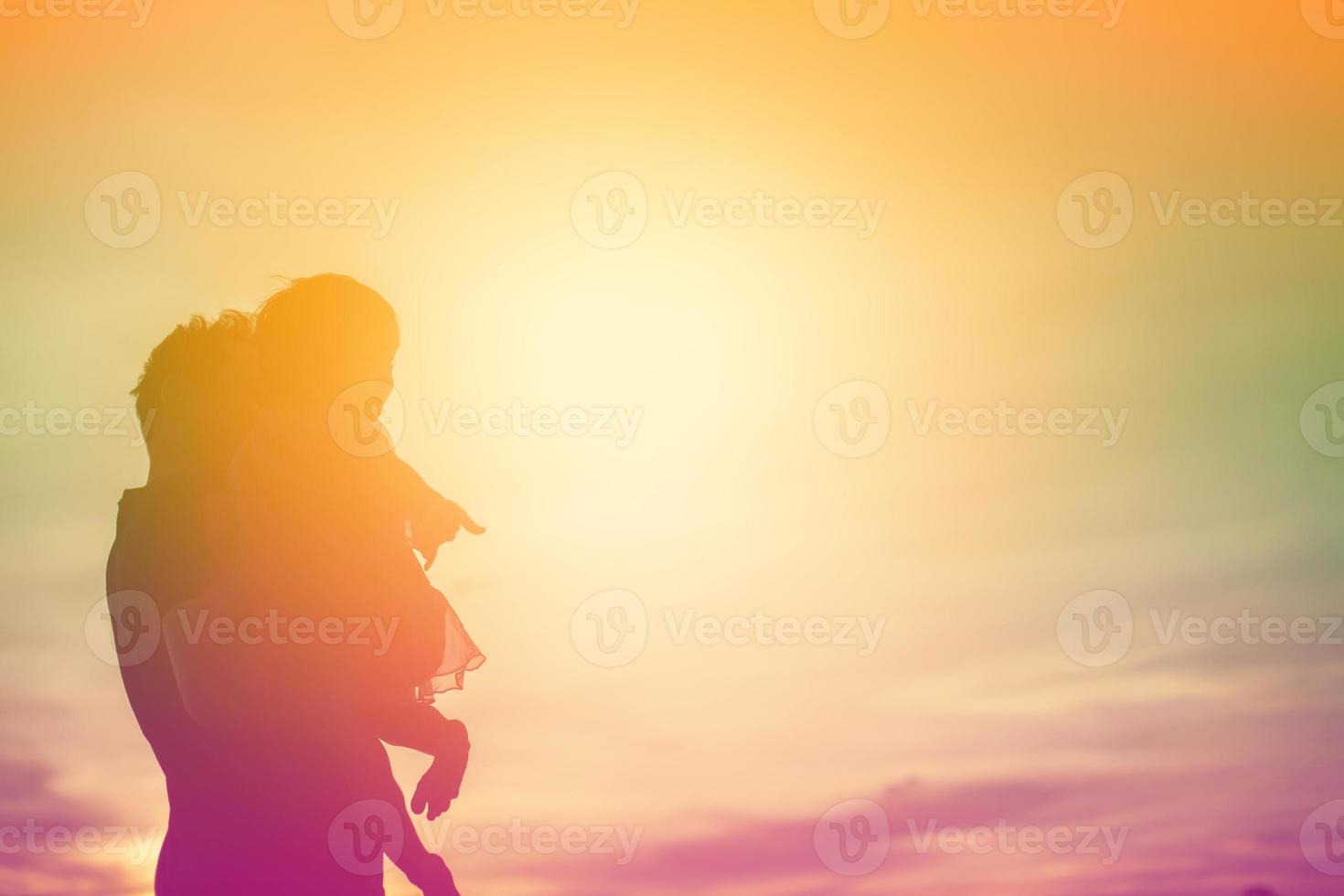 Father took the baby learn to walk at sunset. photo