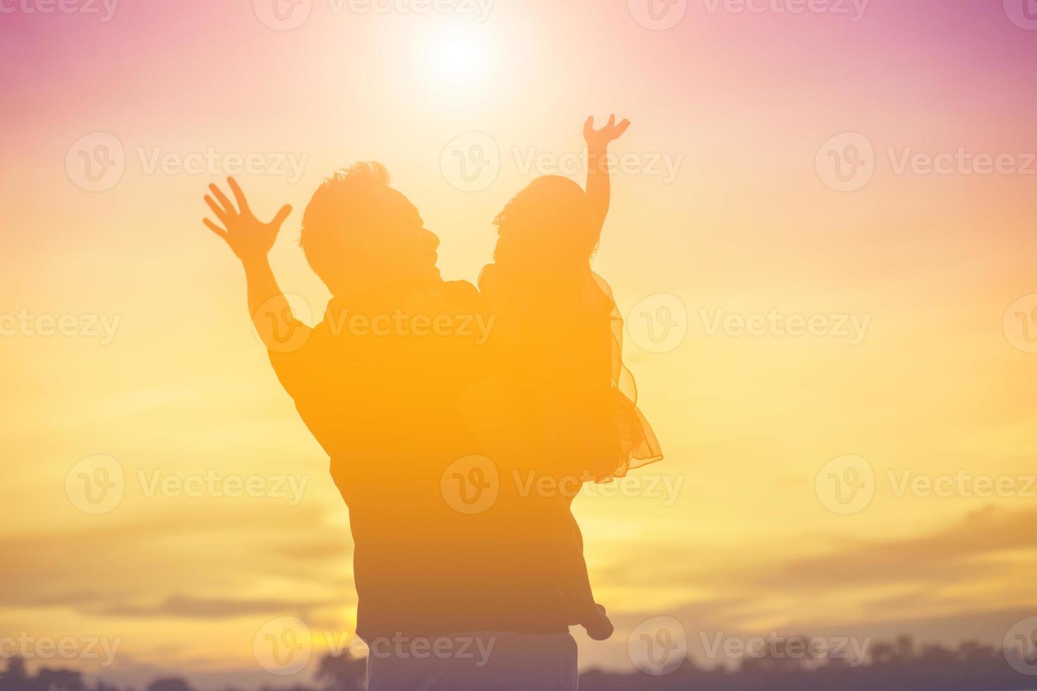 Father took the baby learn to walk at sunset. photo