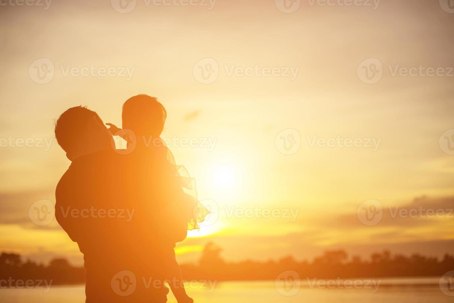 Father took the baby learn to walk at sunset. photo