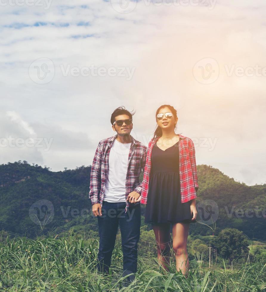 Young hipster couple holding hands walking on the meadow relaxing and natural atmosphere is very natural. photo