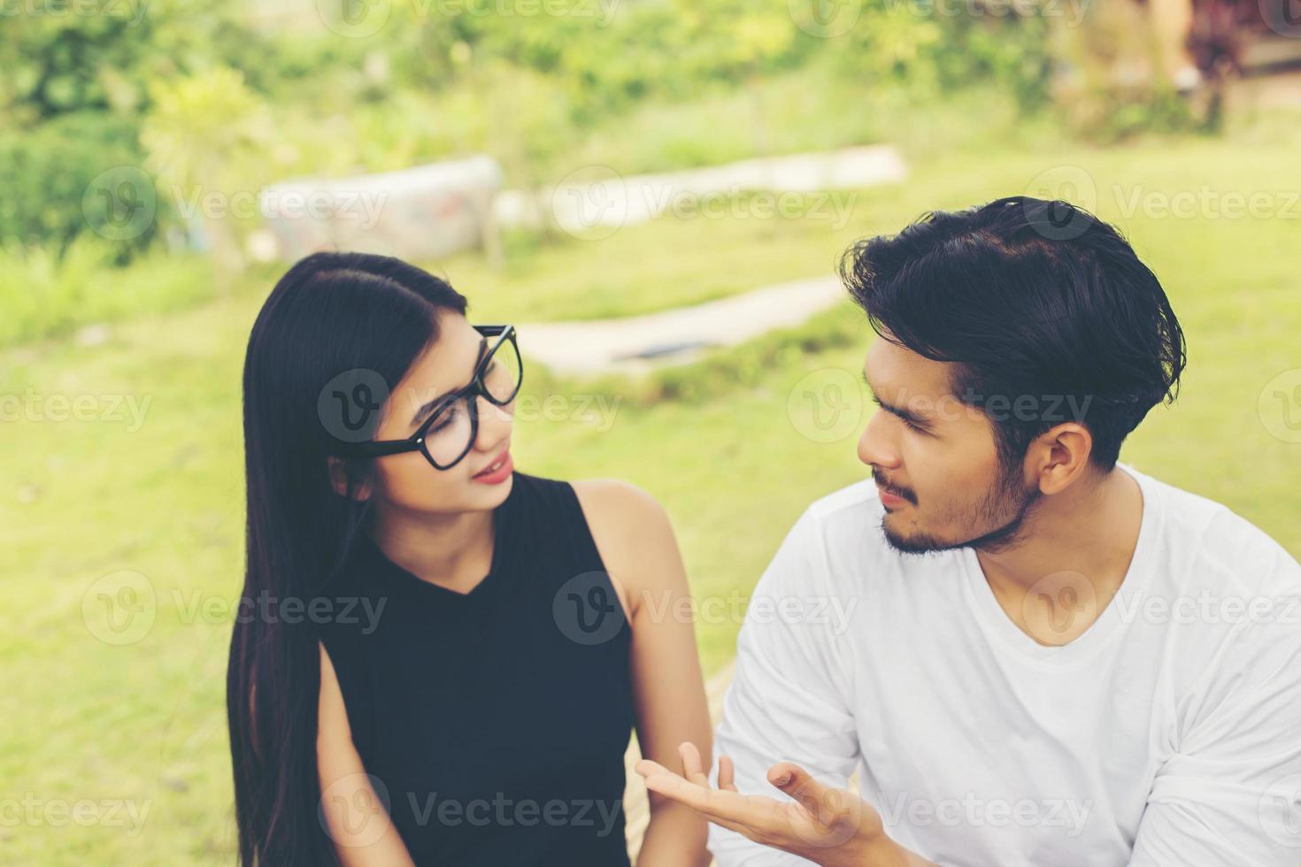 Young hipster couple enjoying a good read together while relaxing outdoors. photo
