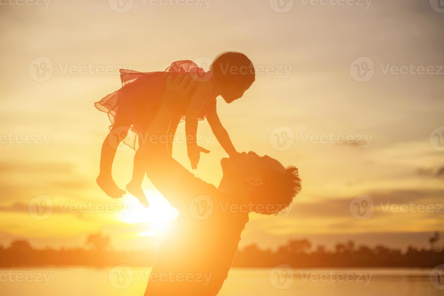 Father took the baby learn to walk at sunset. photo