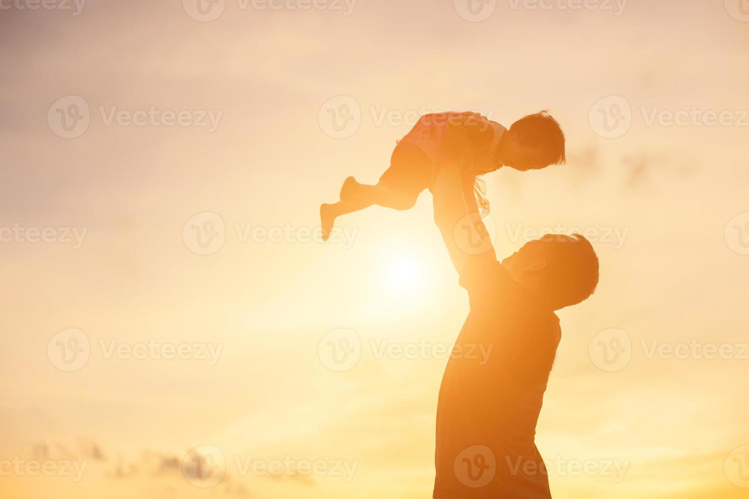 Father took the baby learn to walk at sunset. photo