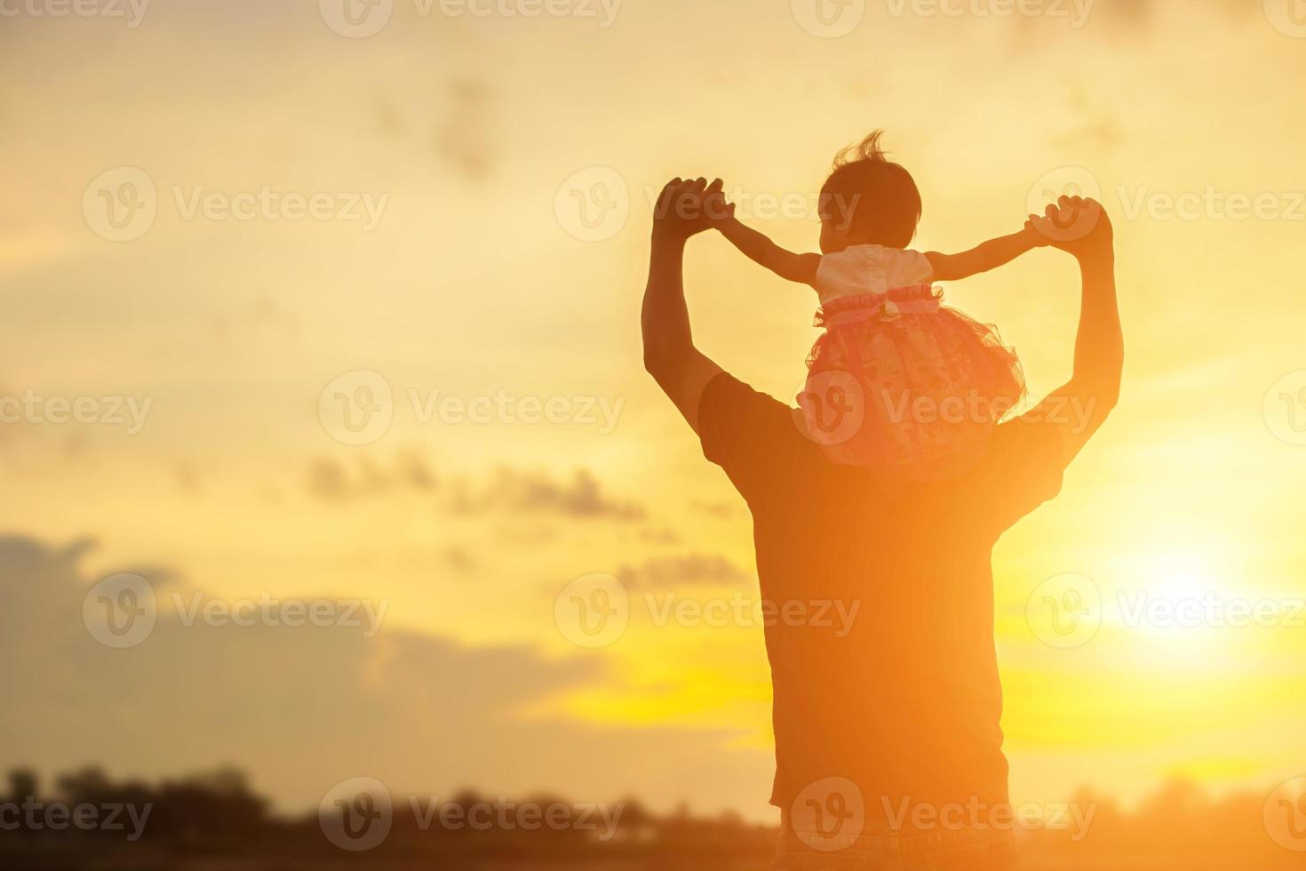 Father took the baby learn to walk at sunset. photo
