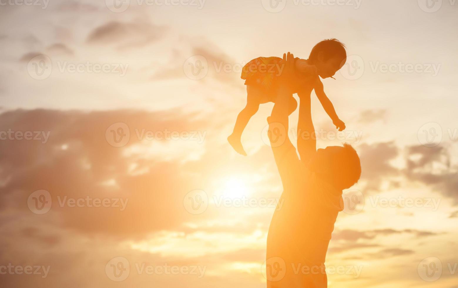Father took the baby learn to walk at sunset. photo