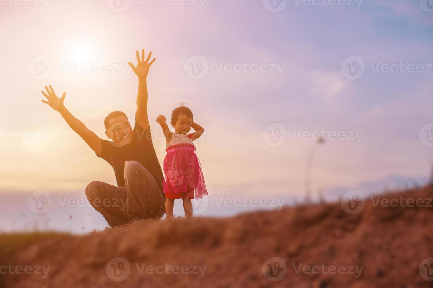 Father took the baby learn to walk at sunset. photo