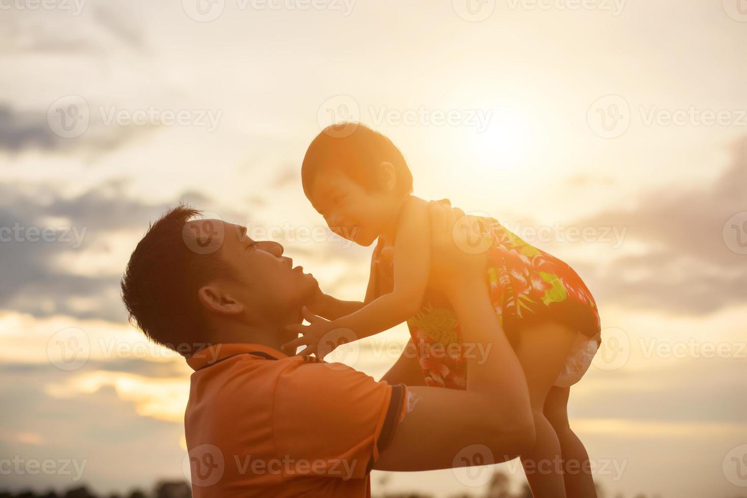 Father took the baby learn to walk at sunset. photo